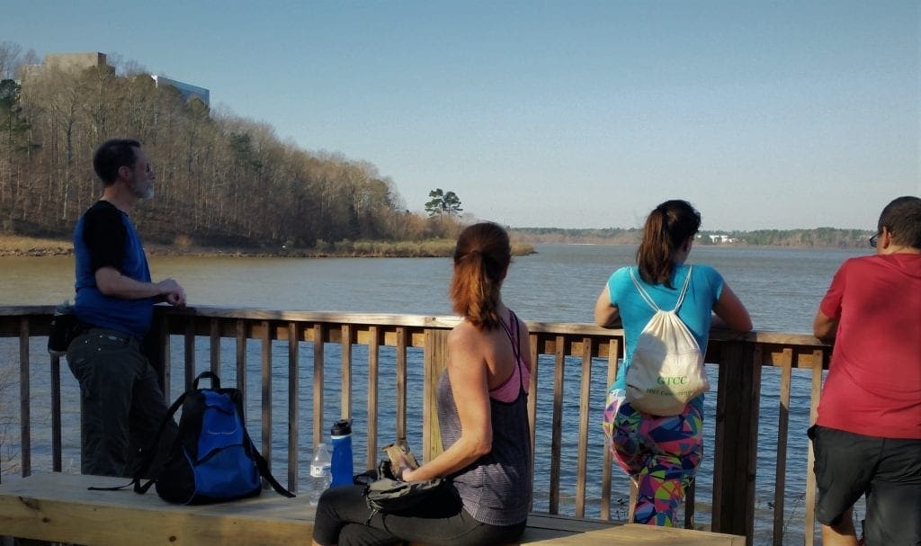 Hikers take a break in the Lake Crabtree overlook along the Black Creek Greenway