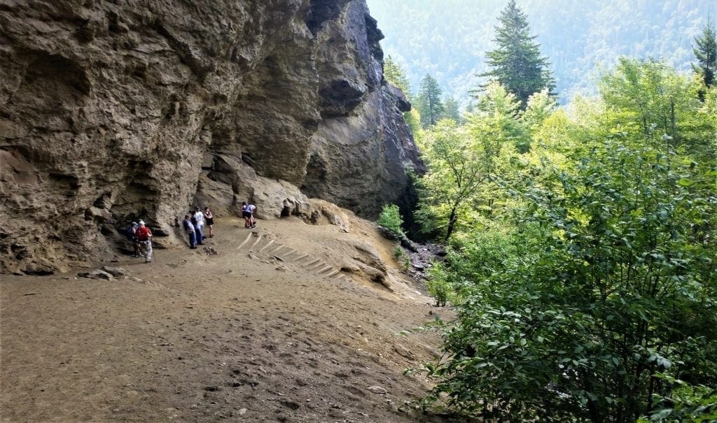 Hikers rest under the Alum Cave bluff.
